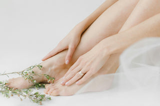Close-up of a person's feet with a ring on a light background