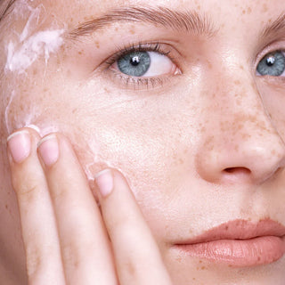 Close-up of a person applying cream to their face