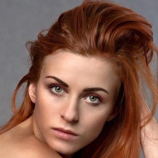 Woman with red hair against a gray background